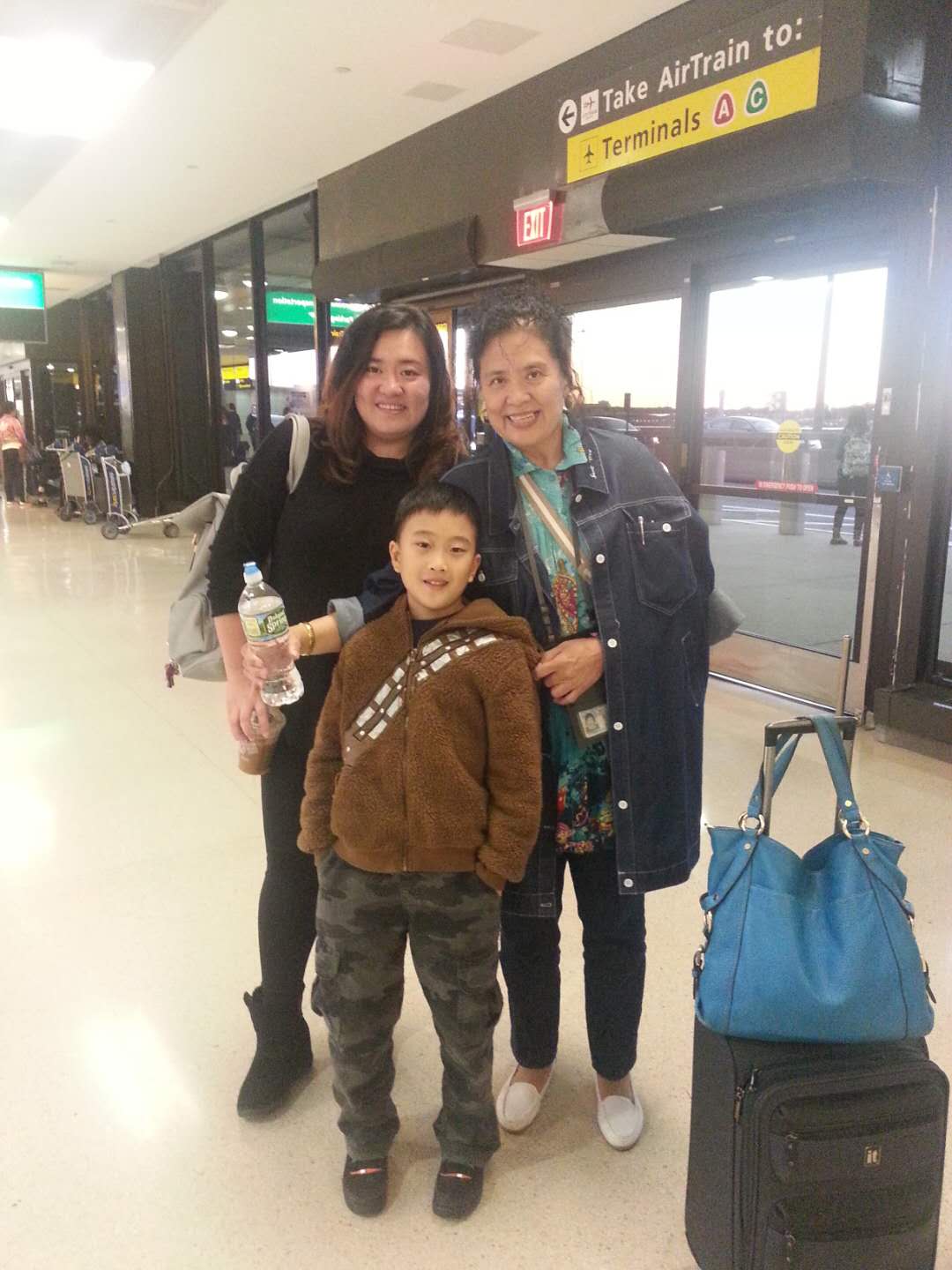 Daniel as a young child standing with his mom and grandma